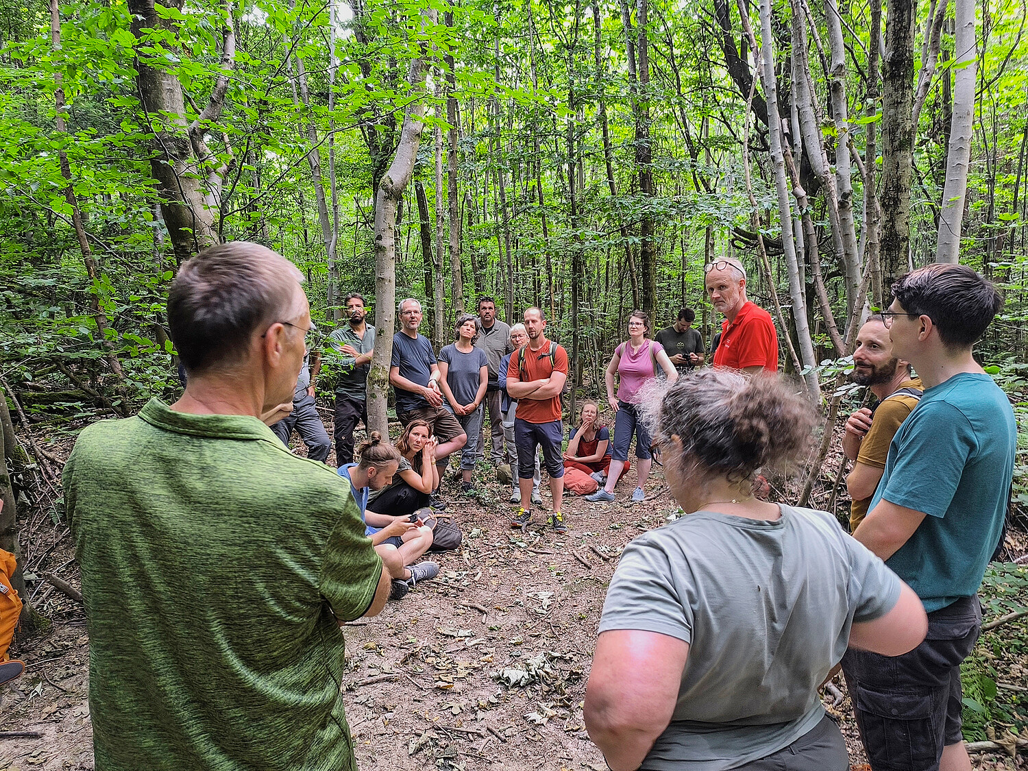 Georg von Graefe (Stadtoberförster von Baden [AG], im roten T-Shirt rechts) und Marcel Murri (im grünen T-Shirt links) führten die Jubiläumsgesellschaft durch das Naturwaldreservat Teufelskeller.