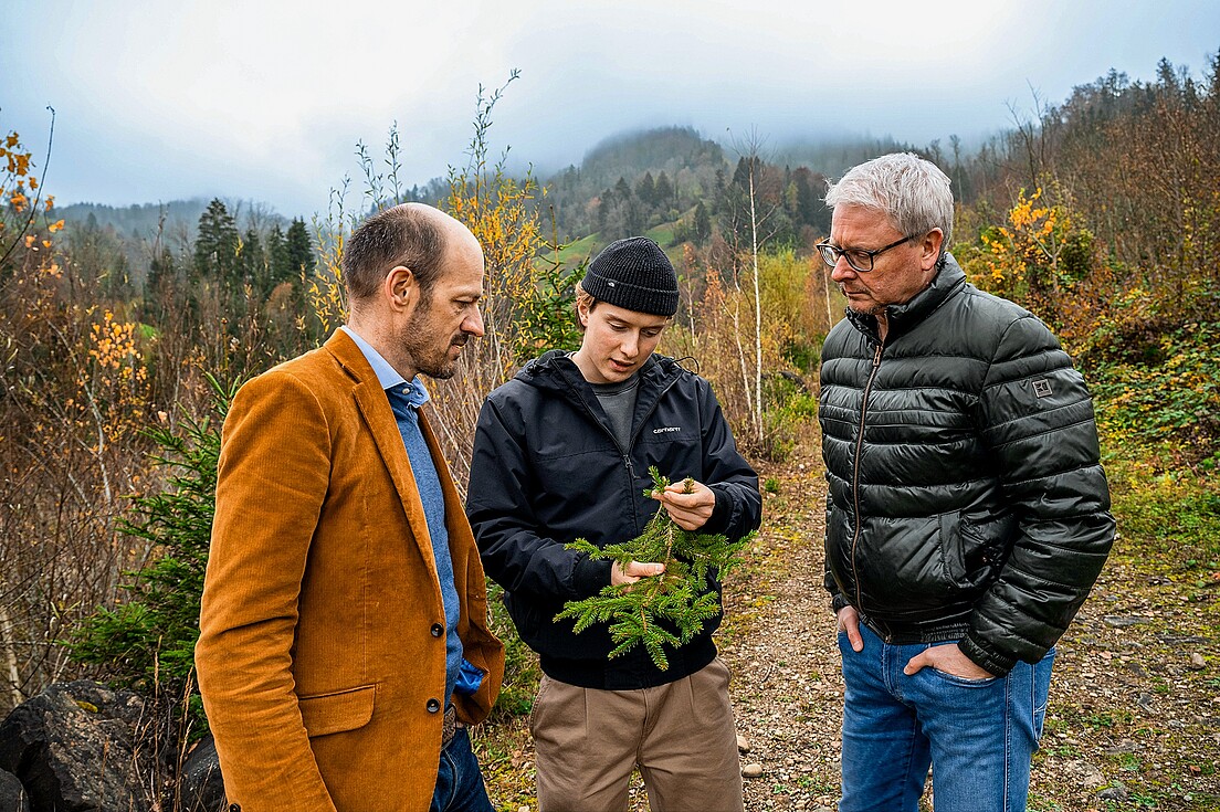 Ramon Riebli erklärt Kurt Zgraggen, Geschäftsführer Schweizer Berghilfe (links), und Christoph Lang, Geschäftsführer ITZ (rechts), wie er ätherische Öle aus dem Wald gewinnen will.